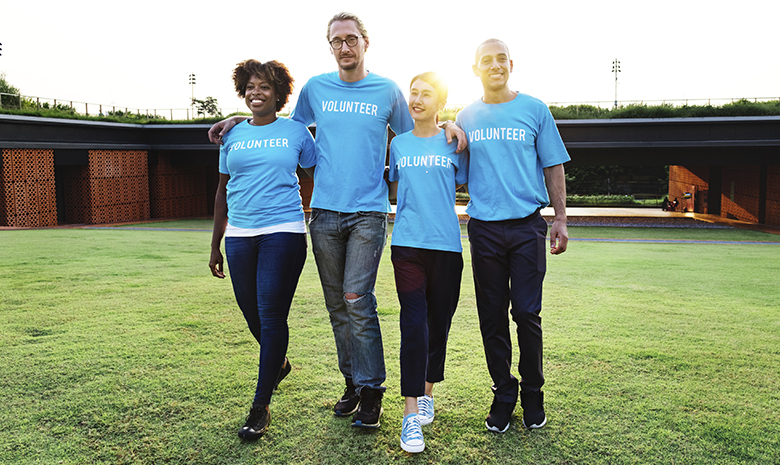 Adults wearing matching blue shirts walking arm in arm